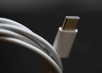 A USB Type-C cable plug for the Apple MacBook Pro, a white cord. The USB-C standard has a reversible connector.