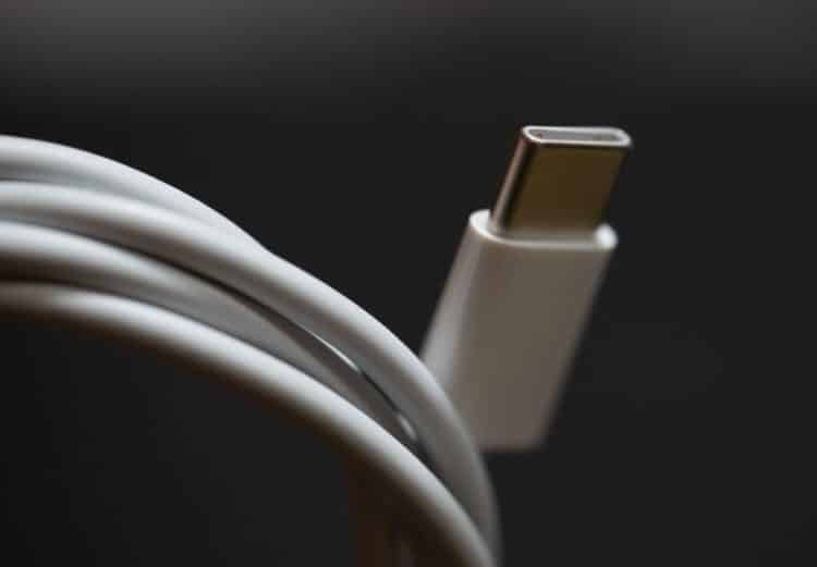 A USB Type-C cable plug for the Apple MacBook Pro, a white cord. The USB-C standard has a reversible connector.
