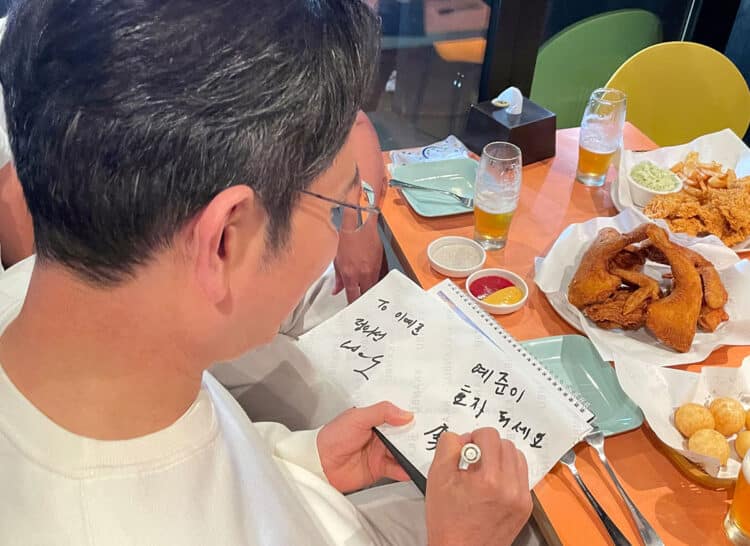 Lee Jae-yong, chủ tịch Samsung Electronics, ký tặng một đứa trẻ và viết "Hãy là một người con hiếu thảo". Ảnh: Yonhap